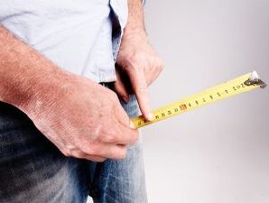 一个男人在用苏打水增加阴茎之前测量阴茎的长度